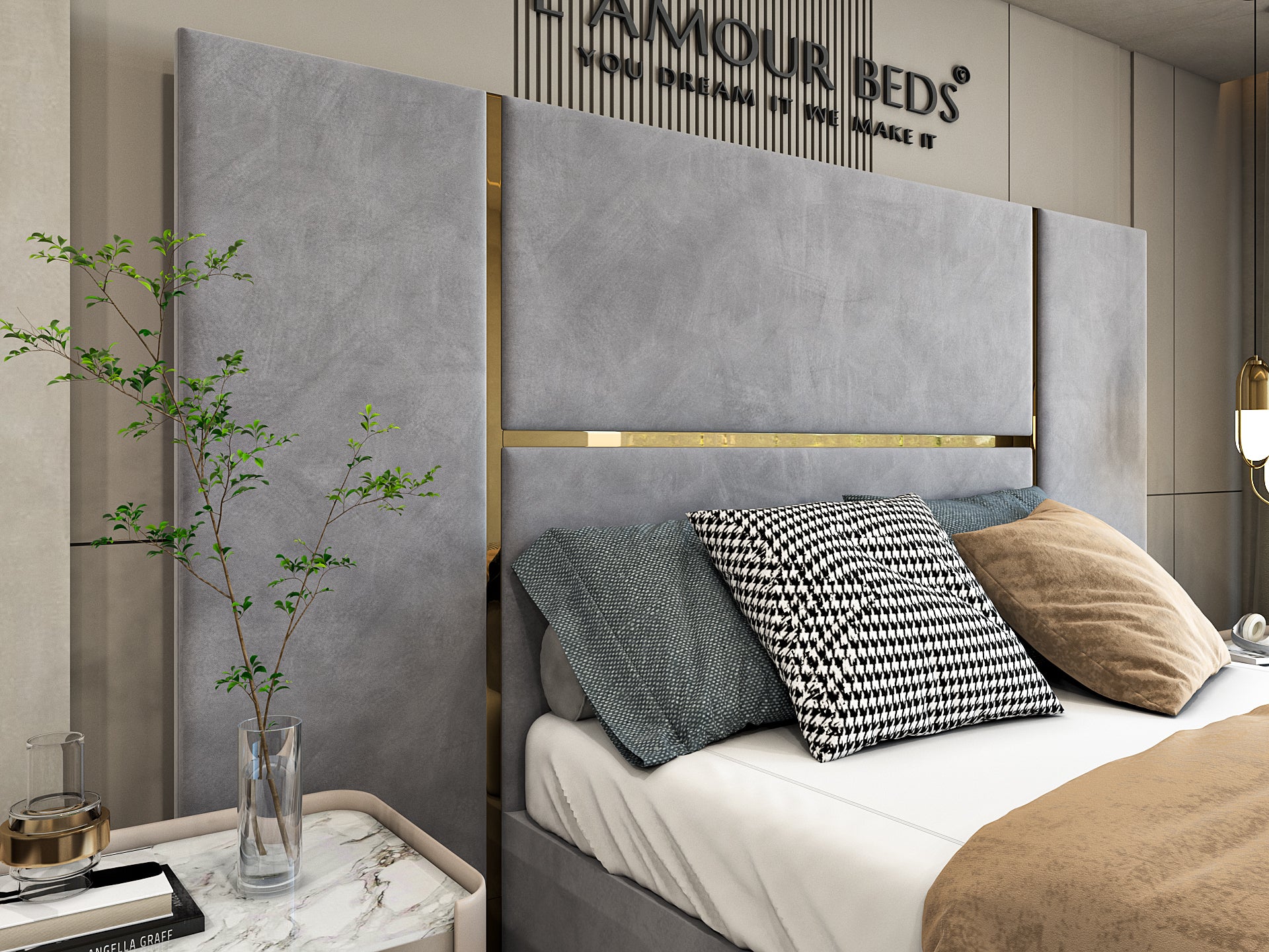 A cozy bedroom with a gray padded headboard, decorative pillows in gray and beige, white bedding, and a soft beige throw. A lit bedside lamp adds warmth.